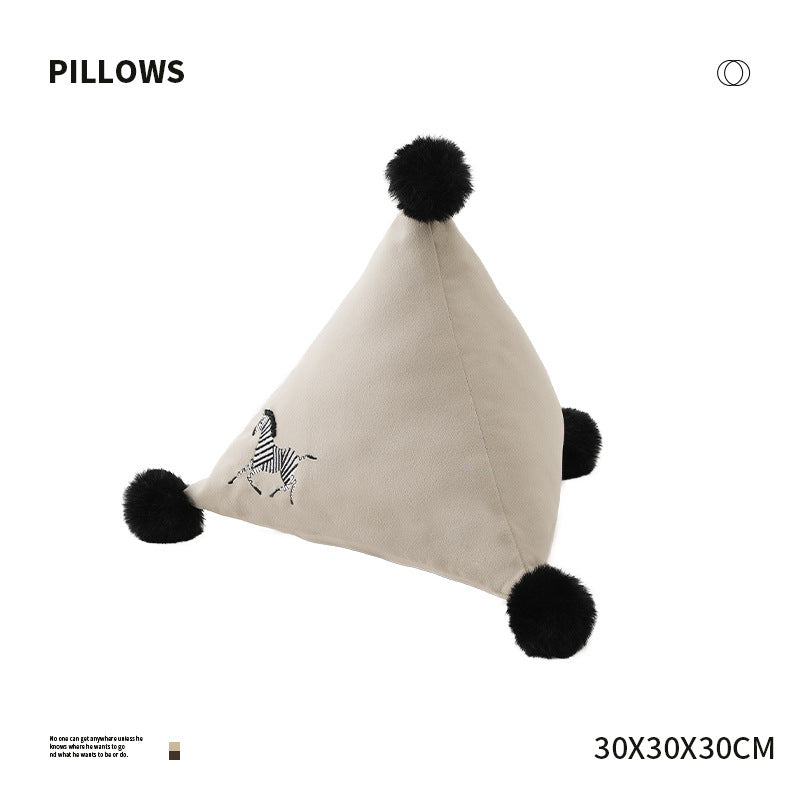 Pyramid-shaped triangle cushion with faux fur pom-poms and zebra embroidery