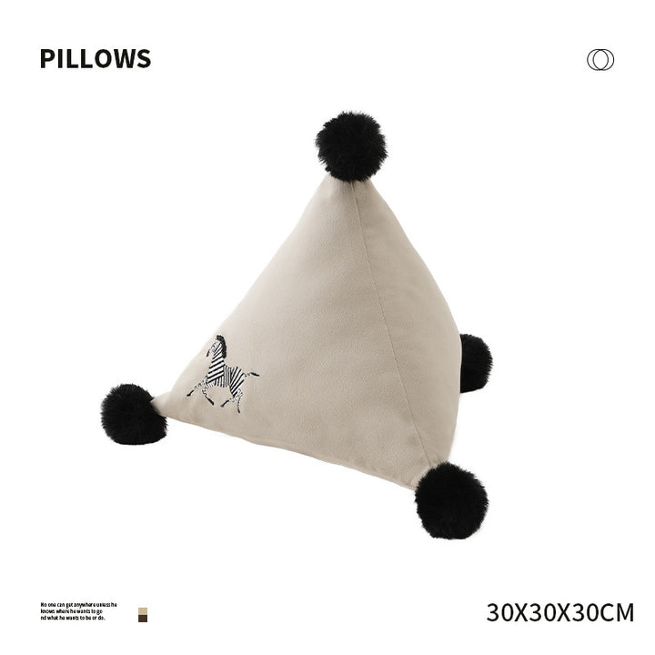 Pyramid-shaped triangle cushion with faux fur pom-poms and zebra embroidery