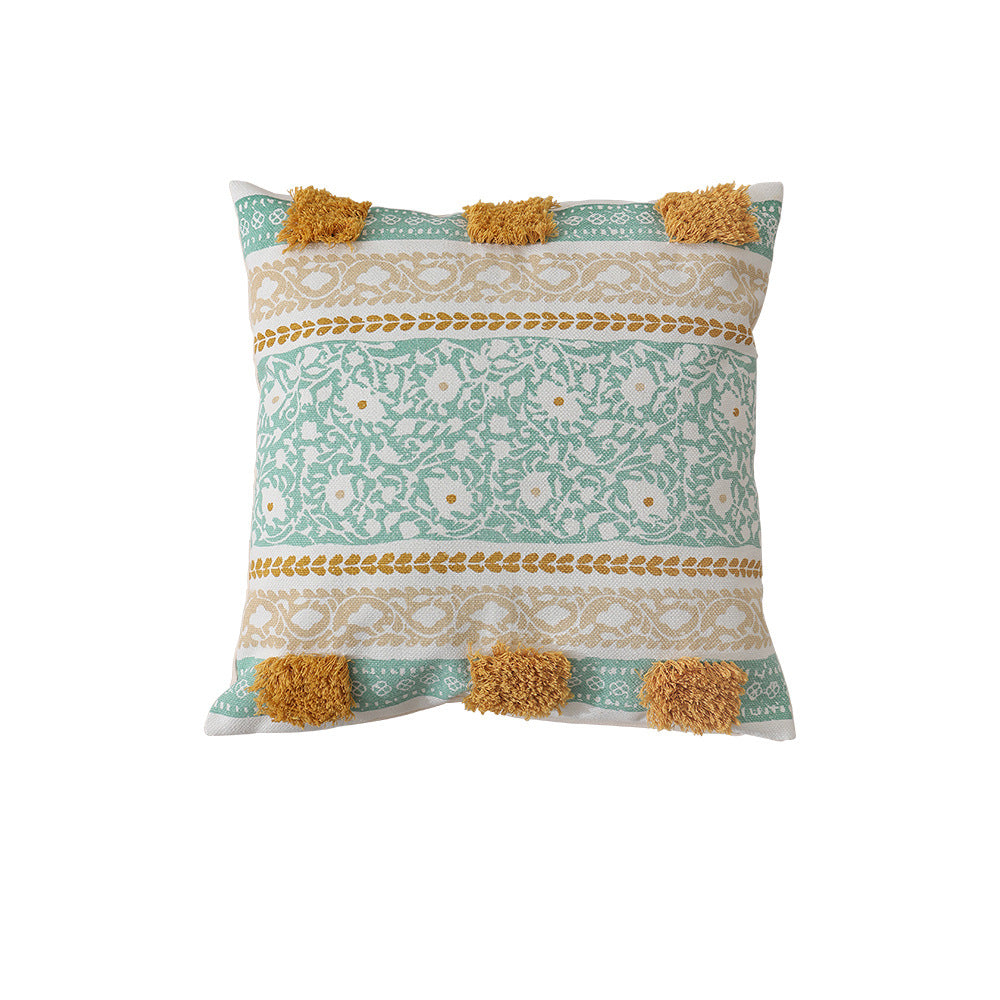 Woven decorative pillow with botanical jacquard pattern and pom-pom trim