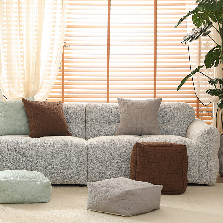 Padded footstool pouf with quilted cover fabric and shape-stable core