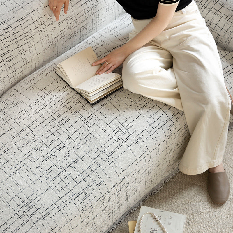 Universal sofa throw made of woven cotton blend with fringes and gentle upholstery cover