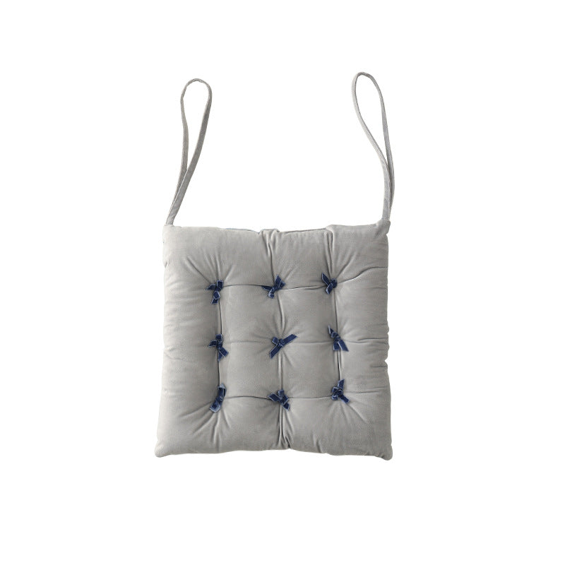 Padded square seat cushion with tufting and attachment ribbons