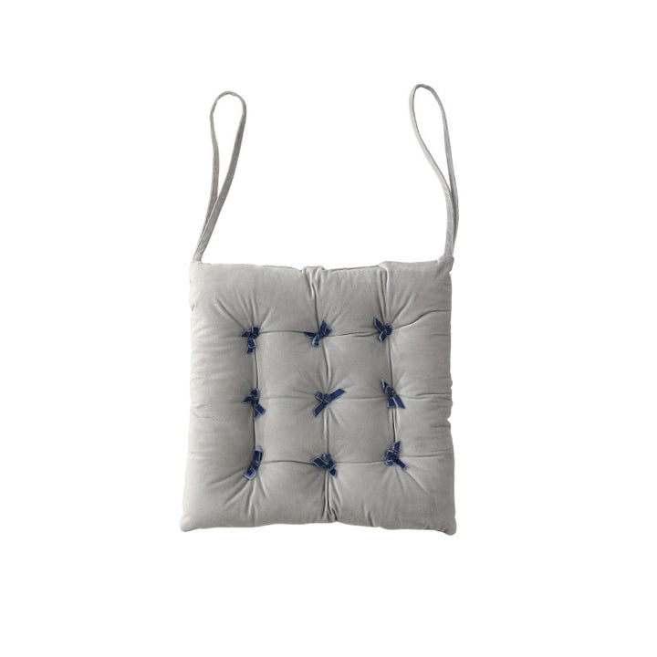 Padded square seat cushion with tufting and attachment ribbons