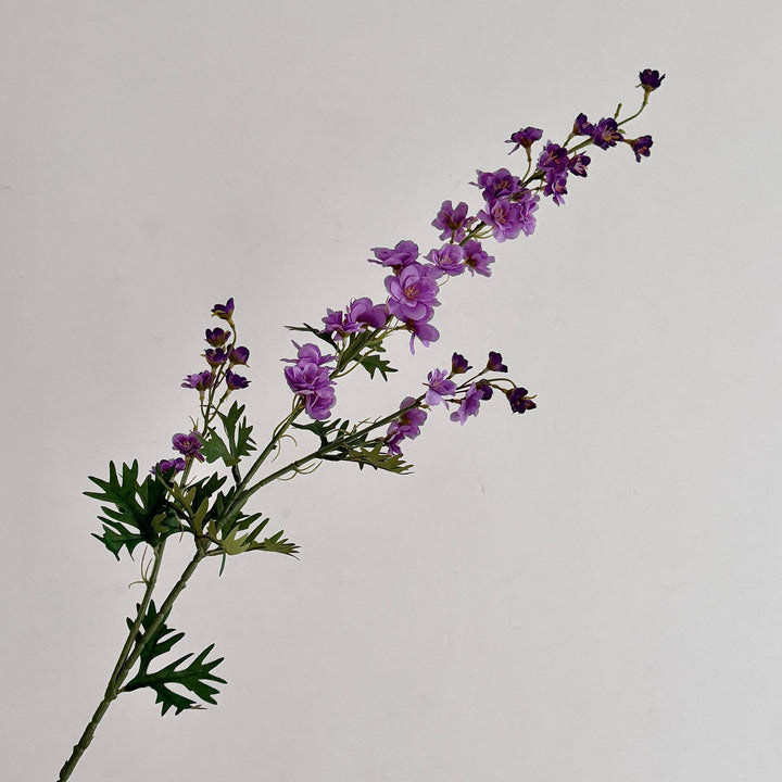 Artificial flower branch with intricately detailed red flowers