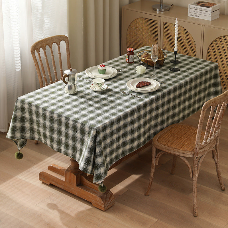 Square tablecloth made of cotton blend fabric with checkered weave pattern and pom-pom corners