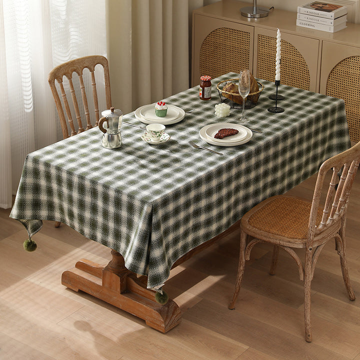 Square tablecloth made of cotton blend fabric with checkered weave pattern and pom-pom corners