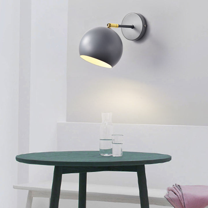 Adjustable matte metal globe wall lamp with brass pivot arm