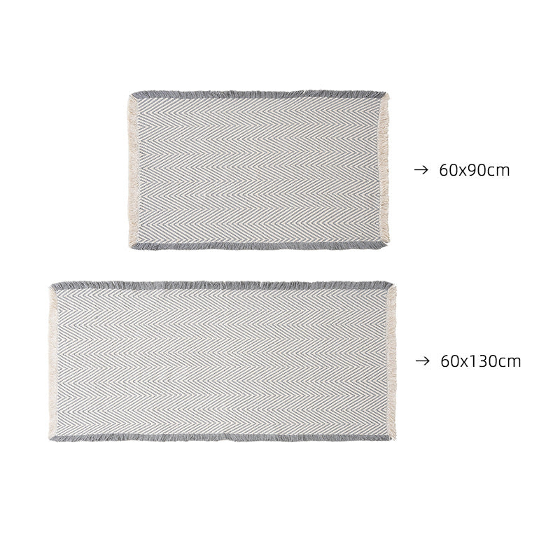 Handwoven cotton bath mat with herringbone pattern and fringes