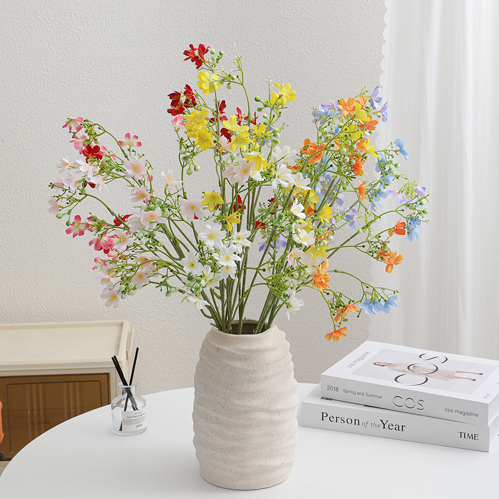 Artificial flower branch with delicate blue flowers and green berries