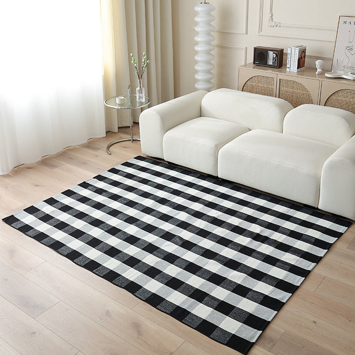 Woven living area rug with large check pattern and flat cotton texture