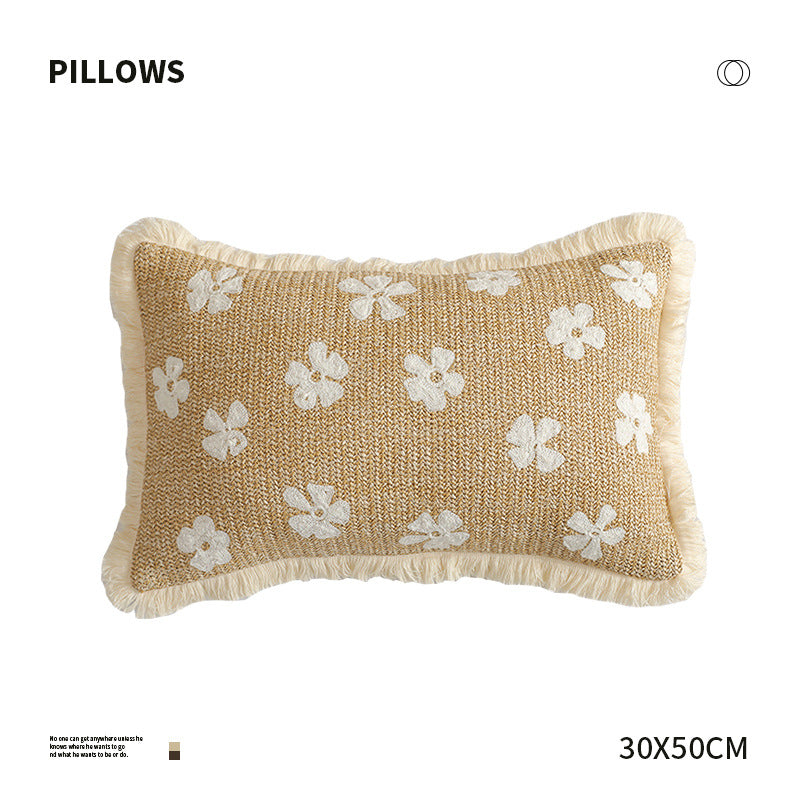 Rectangular woven decorative pillow with contrasting flower tufting and fringe trim