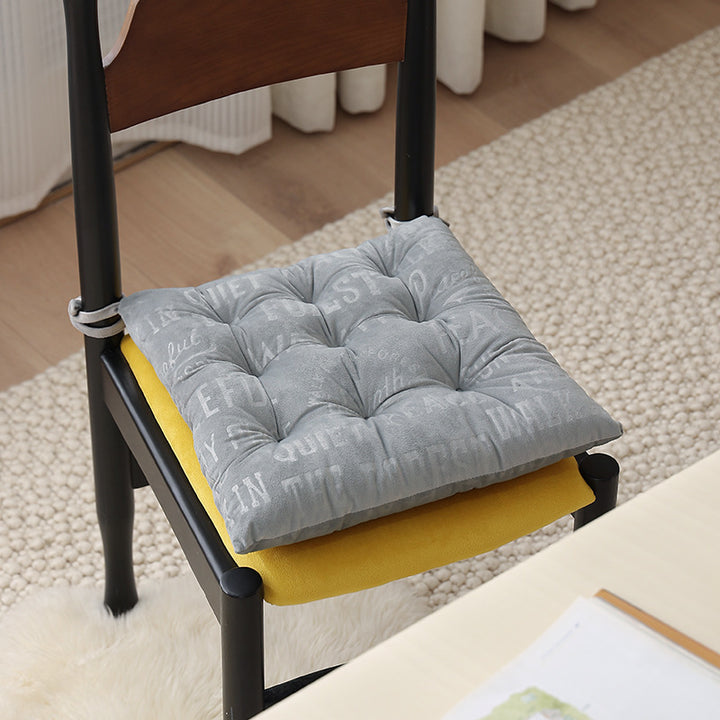 Padded square seat cushion with tufting and attachment ribbons