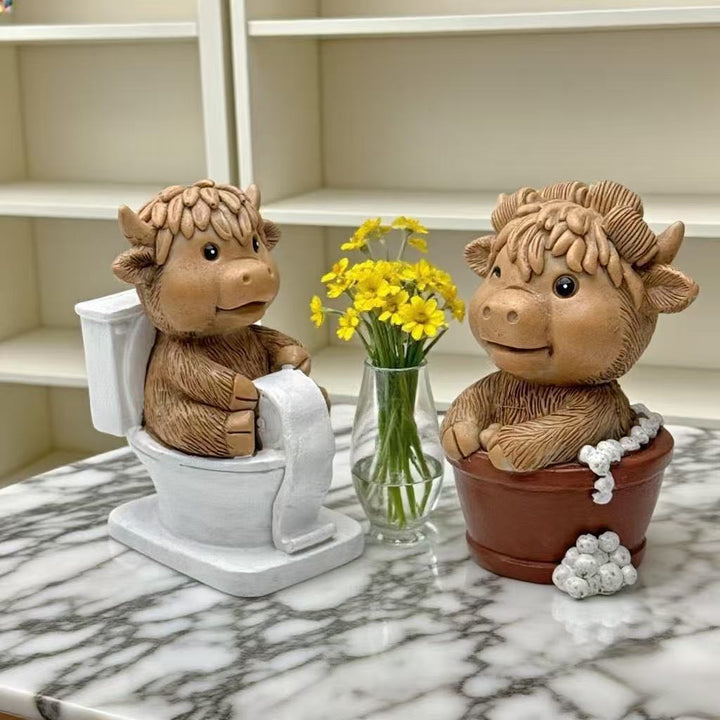 Funny decorative figure of a Highland cow on toilet