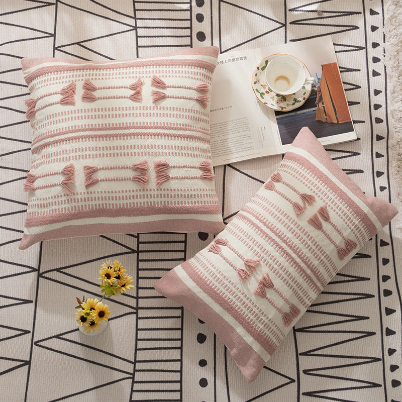Woven decorative cushion cover with ordered tassel application and structured jacquard weaving