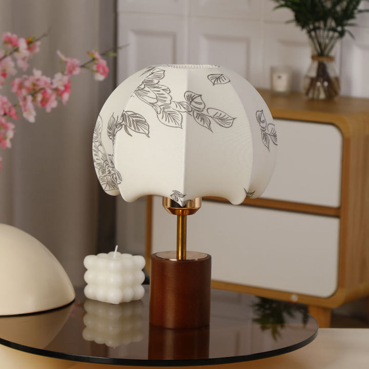 Sculptural table lamp with wooden base, brass stem, and cardboard shade