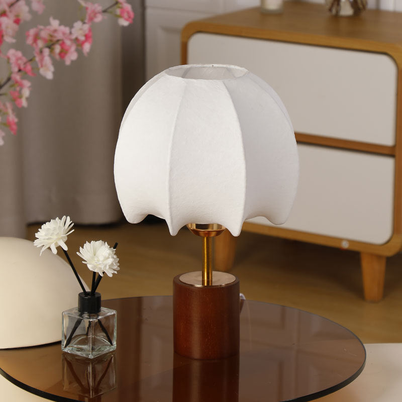 Sculptural table lamp with wooden base, brass stem, and cardboard shade