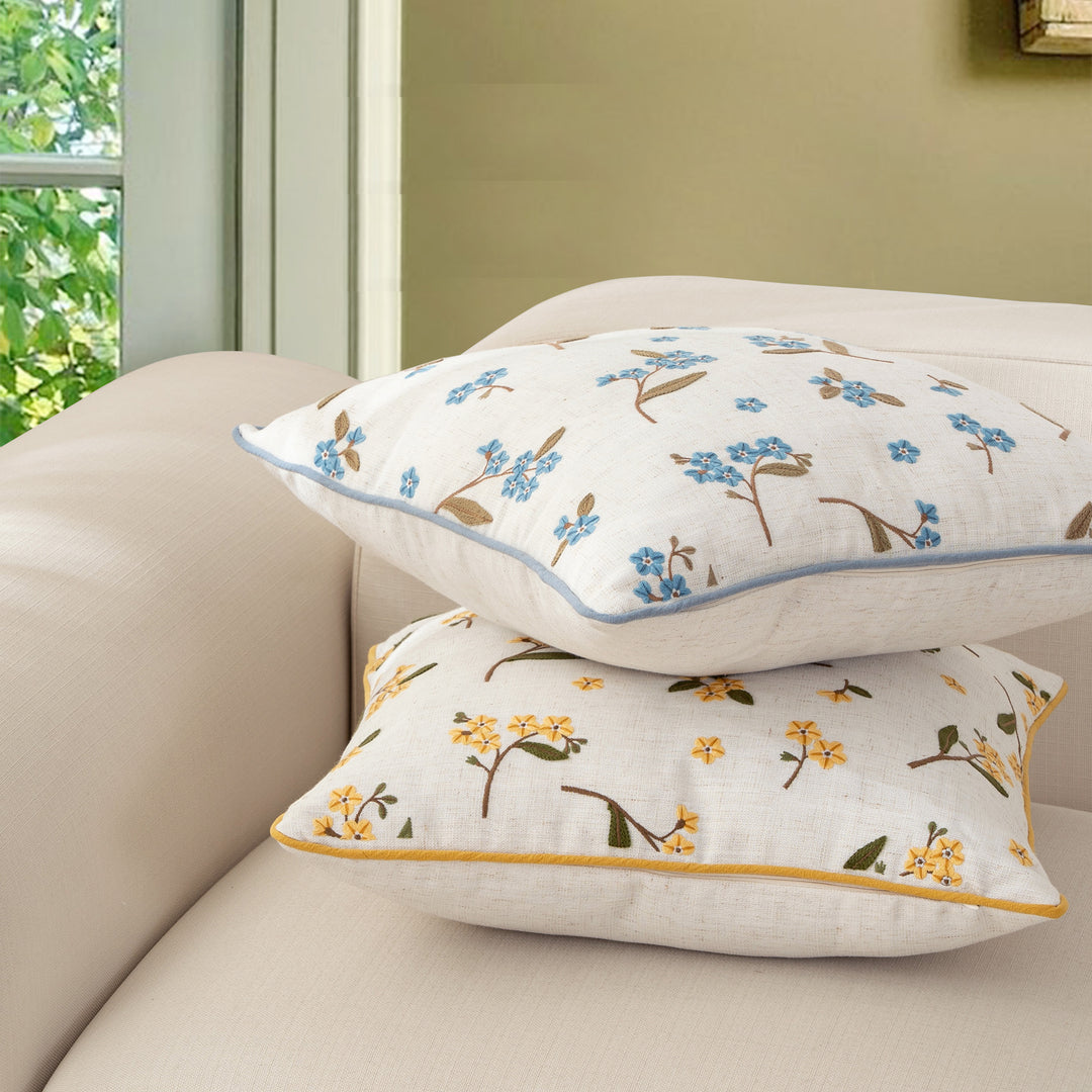 Decorative embroidered cushion cover made of linen blend with floral yellow flower appliqué and piping