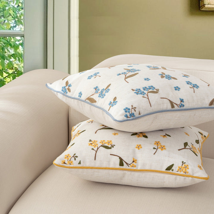 Decorative embroidered cushion cover made of linen blend with floral yellow flower appliqué and piping