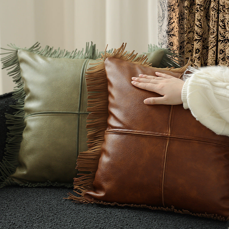 Decorative faux leather cushion with fringes and decorative seam