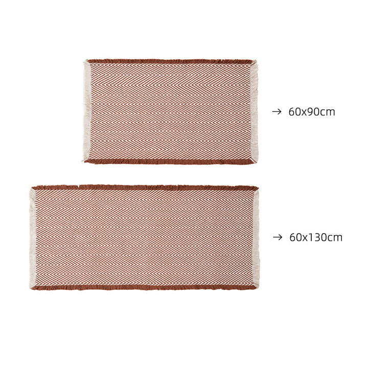 Handwoven cotton bath mat with herringbone pattern and fringes