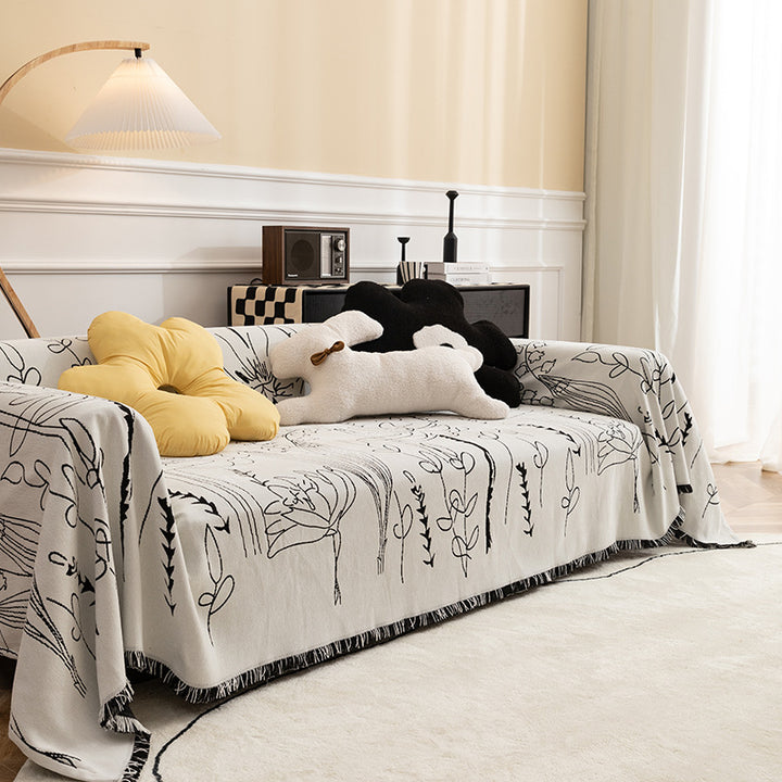 Fine woven sofa cover and furniture throw with floral line drawing and decorative fringed edge