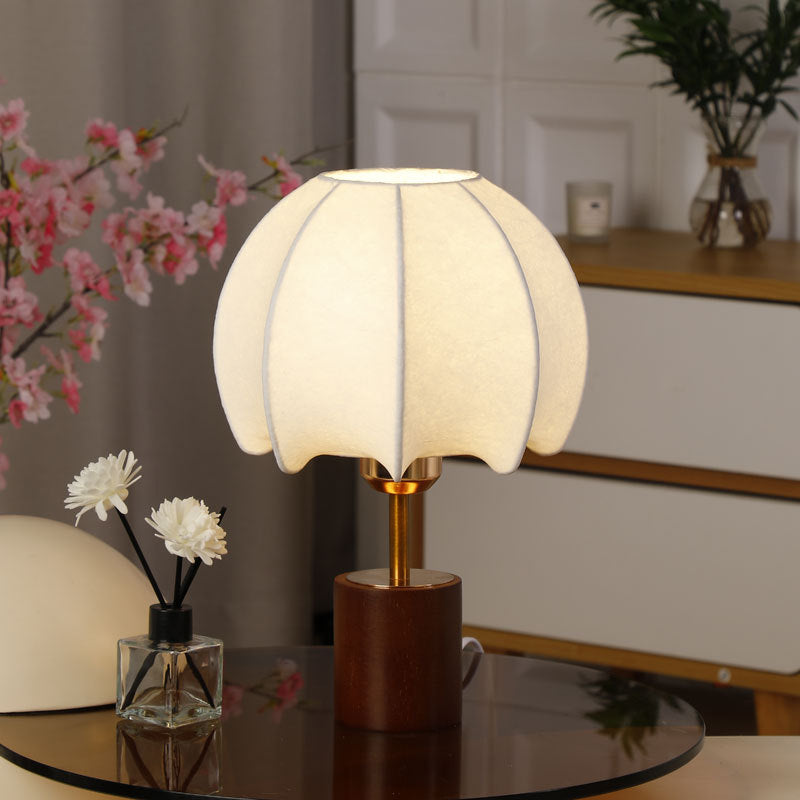 Sculptural table lamp with wooden base, brass stem, and cardboard shade