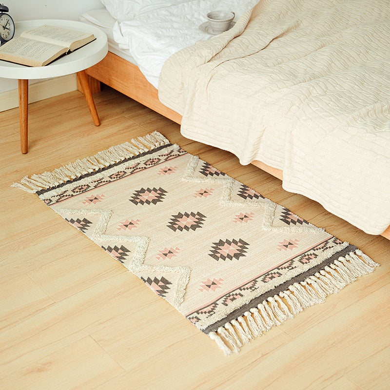 Hand-tufted bathroom mat with fringes, decorative dot-and-dash pattern and non-slip backing