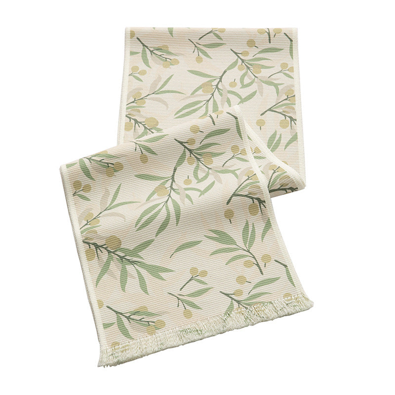 Woven table runner with floral jacquard pattern and fringed edge