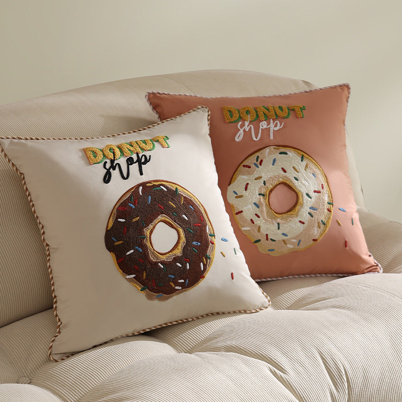 Square decorative cushion with embroidered donut motif and decorative piping edge