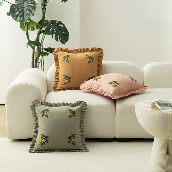 Square decorative pillow with ruffled edges and hand-stitched flower appliqués