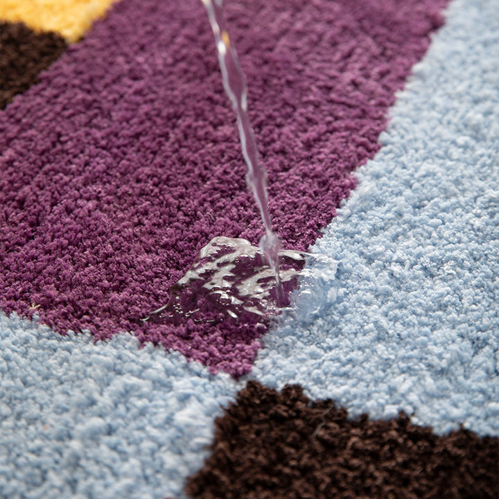 High-pile bath mat with geometric color block design and non-slip underside