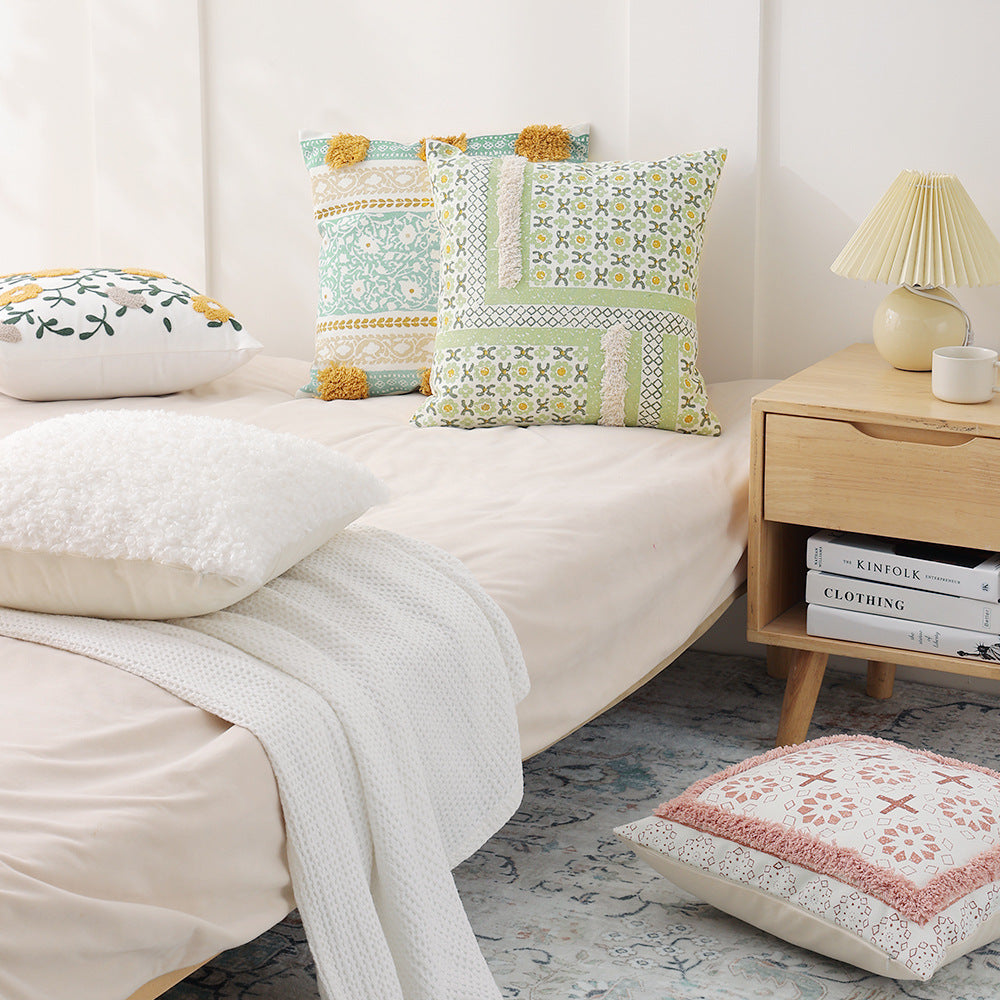 Woven decorative pillow with botanical jacquard pattern and pom-pom trim
