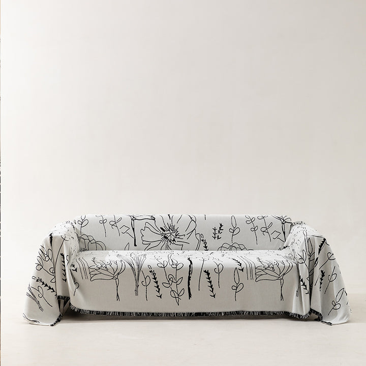 Fine woven sofa cover and furniture throw with floral line drawing and decorative fringed edge
