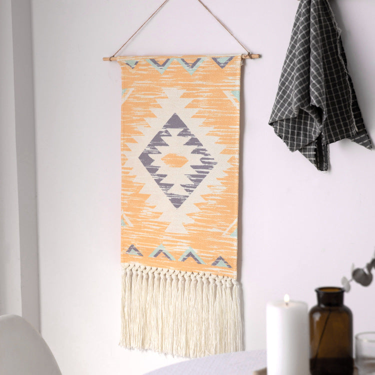 Woven Boho wall tapestry in Ethno design with long fringes and wood stick