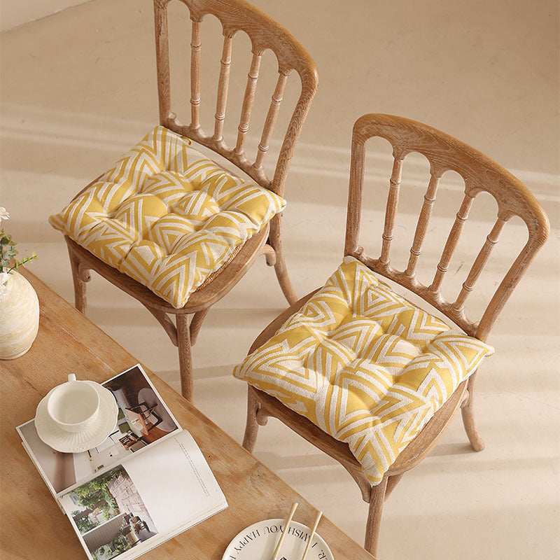 Padded quilted seat cushion with colorful button applications and non-slip underside