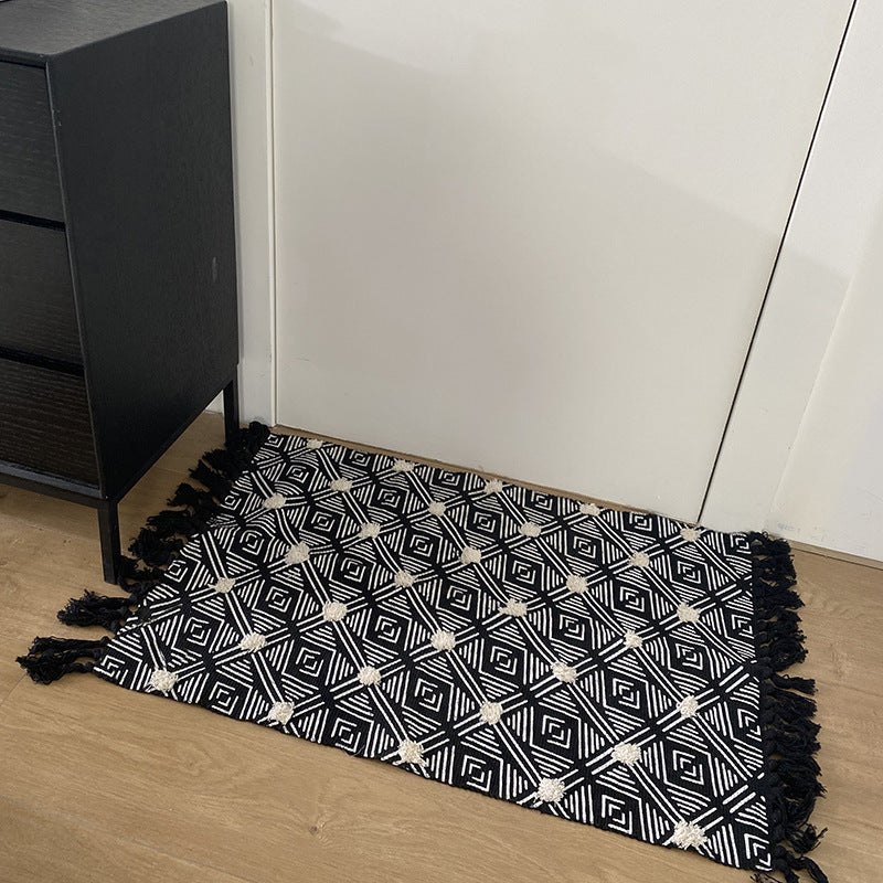 Hand-tufted bathroom mat with fringes, decorative dot-and-dash pattern and non-slip backing