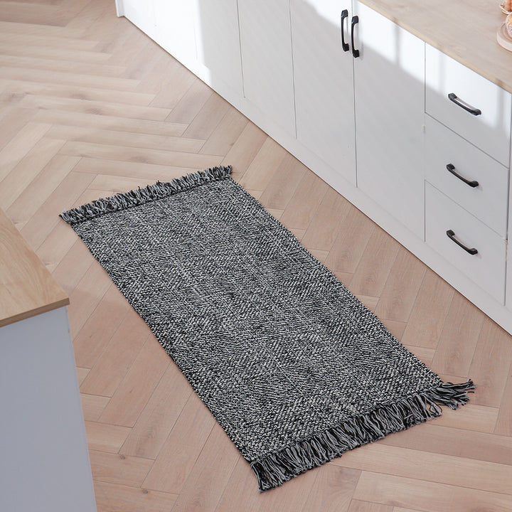 Woven table runner made of cotton blend with fine structure and herringbone look as well as decorative fringes