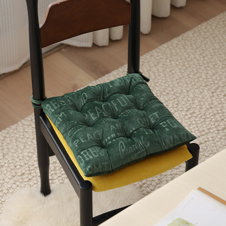 Padded square seat cushion with tufting and attachment ribbons