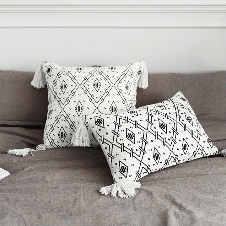Square decorative cushion cover made of cotton blend with handwoven texture, geometric diamond print, and corner tassels