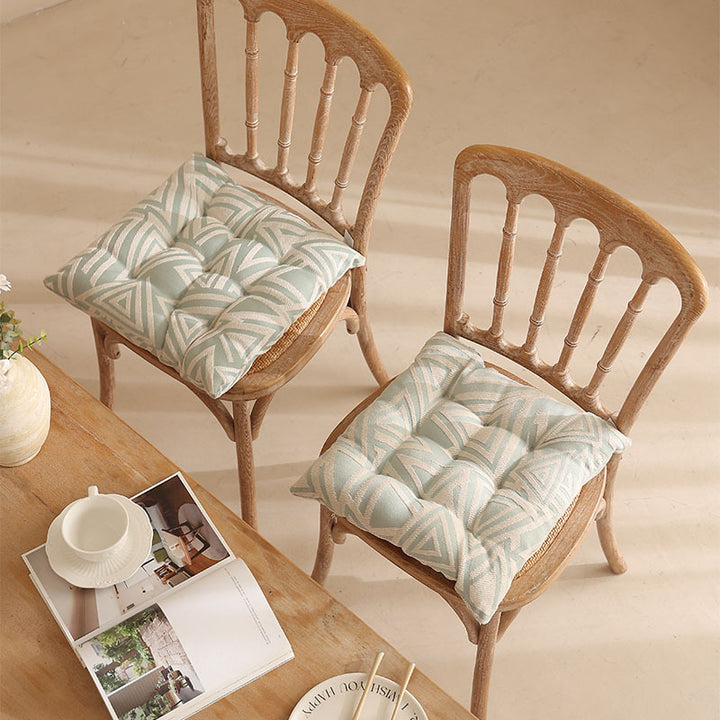 Padded quilted seat cushion with colorful button applications and non-slip underside