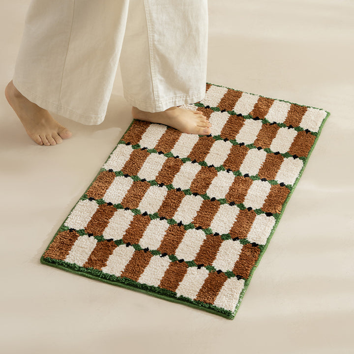 Hand-tufted bathroom mat with a velvety pile, non-slip latex backing, and geometric honeycomb check pattern