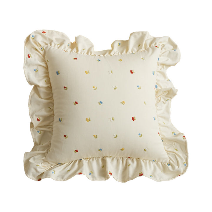 Decorative cushion with ruffles and embroidered flower pattern