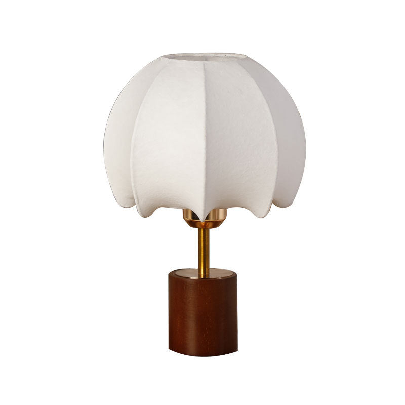 Sculptural table lamp with wooden base, brass stem, and cardboard shade