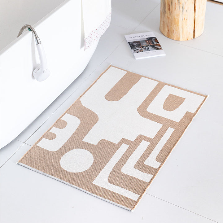 Flat-woven bath mat with abstract geometric pattern