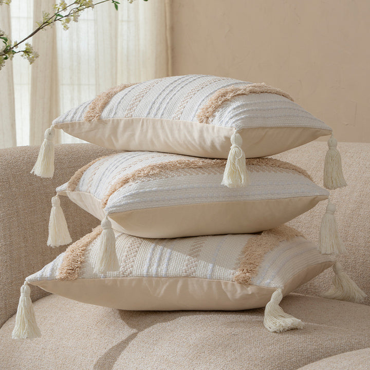 Square decorative cushion with boucle stripes, woven texture, and corner tassels