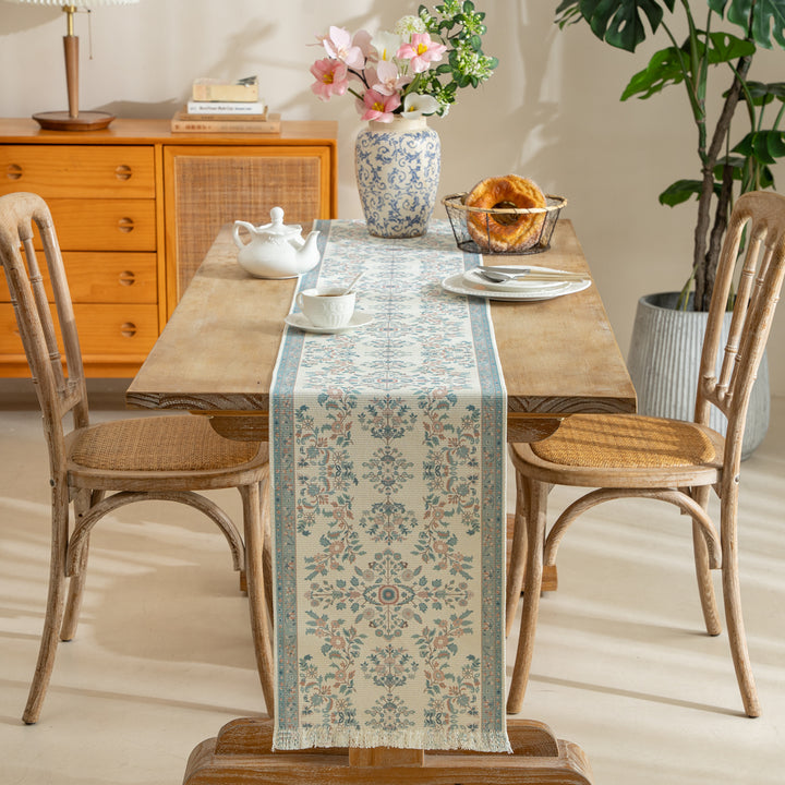 Vintage-inspired woven table runner with floral border and fringes