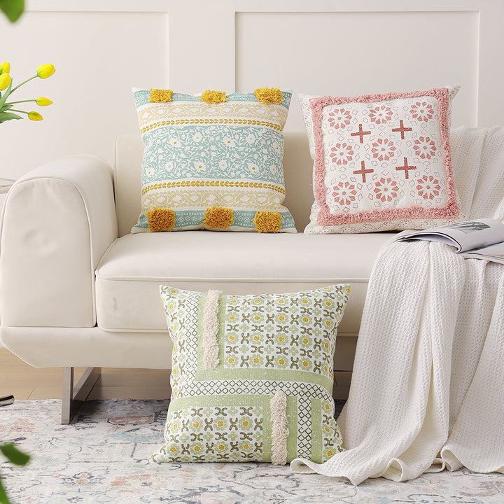 Woven decorative pillow with botanical jacquard pattern and pom-pom trim
