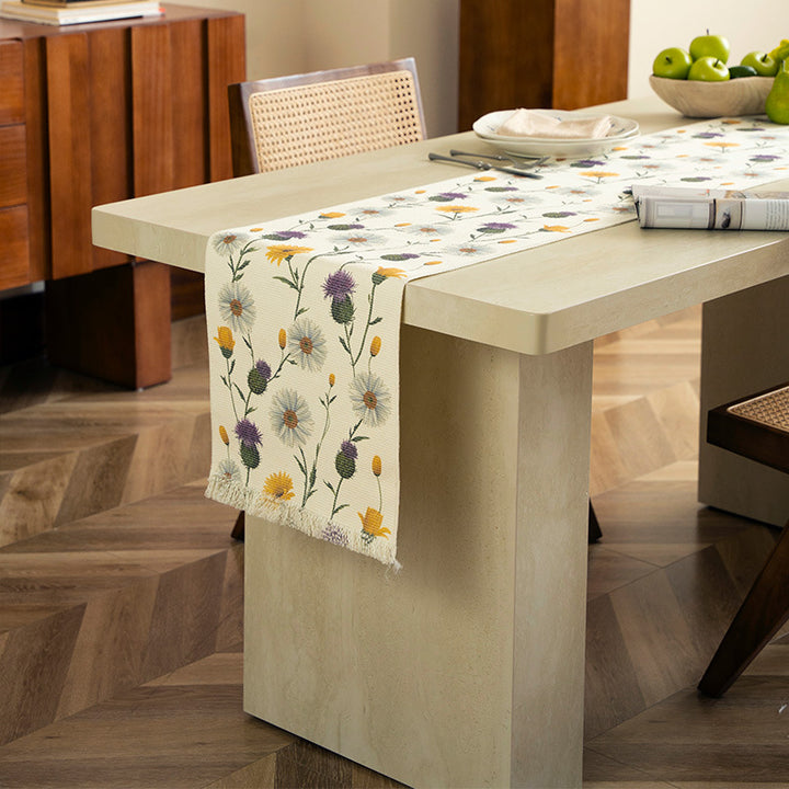 Woven table runner with floral embroidery and fringe trim
