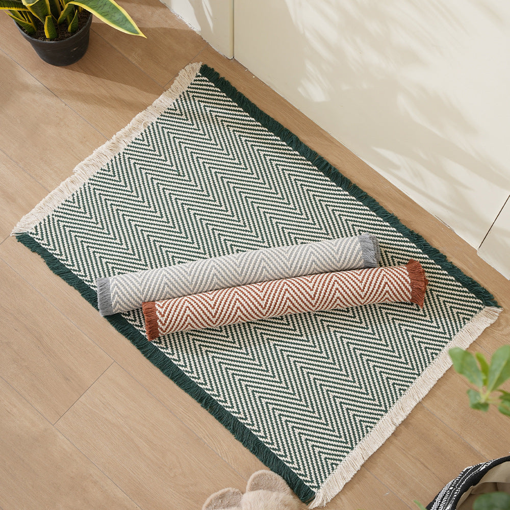 Handwoven cotton bath mat with herringbone pattern and fringes