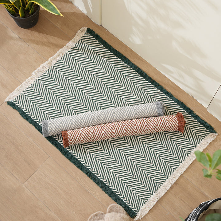 Handwoven cotton bath mat with herringbone pattern and fringes